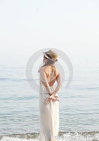 Youg calm dreaming woman standing alone near sea Stock Photo