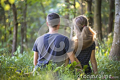 Youg couple, man and a woman sitting together outdoors enjoying nature Stock Photo