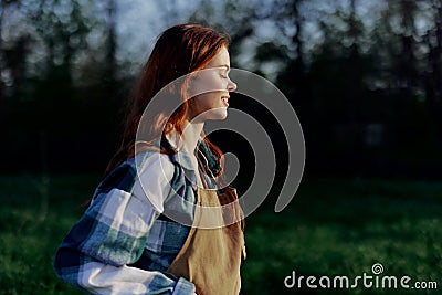 Young active woman relaxing in nature in summer and watching the sunset in the distance Stock Photo