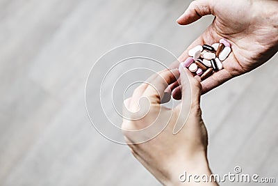 Young addicted woman is deciding which pill of drug to eat Stock Photo
