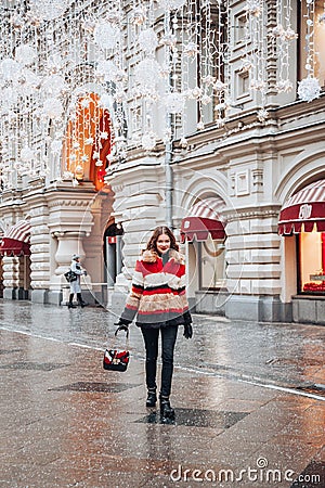 Young and adorable russian girl posing in front of Gum famous shop in Moscow on the Red Square through winter holiday Editorial Stock Photo