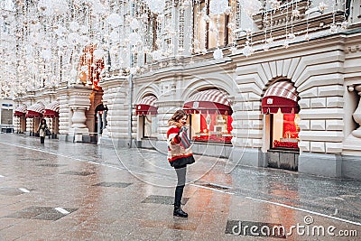 Young and adorable russian girl posing in front of Gum famous shop in Moscow on the Red Square through winter holiday Editorial Stock Photo