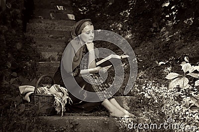 A woman sitting on the steps and reading a book Stock Photo