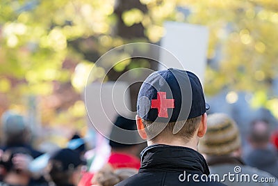 A young adult in a black cap with a red cross Editorial Stock Photo