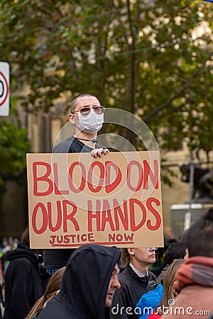 Young adult demonstrator holding placard in the crowd Editorial Stock Photo