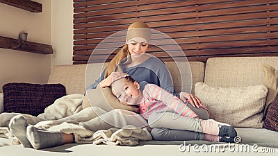 Young adult female cancer patient spending time with her daughter at home, relaxing. Cancer and family support concept. Stock Photo