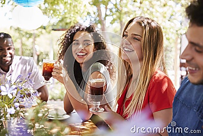 Young adult friends socialising at a table in a garden Stock Photo