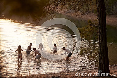 Young adult friends splashing and having fun in a lake Stock Photo