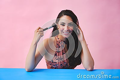 young adult latin beauty woman with makeup brush on studio background Stock Photo