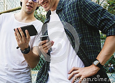 Young adult male friends on the basketball court using smartphones millennials concept Stock Photo