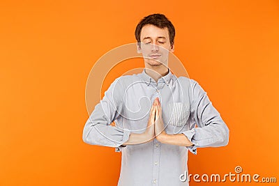 Young adult man closed eyes and prays. Stock Photo
