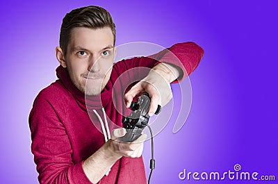 Young adult playing video games, purple background Stock Photo