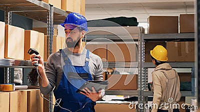 Young adult scanning barcodes on boxes in warehouse Stock Photo