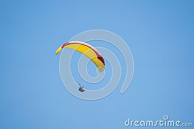 A person flying a kite high in the air with a parachute Editorial Stock Photo