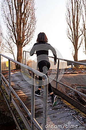 Young adult woman is running on a ship gangway in the morning Stock Photo