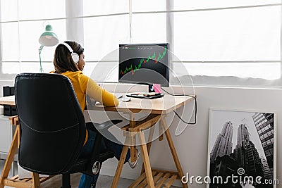 Young adult woman studying stock market data at home Stock Photo