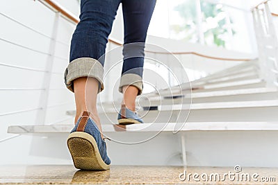 Young adult woman walking up the stairs Stock Photo