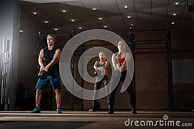 Young adults doing exercises with kettle bells Stock Photo
