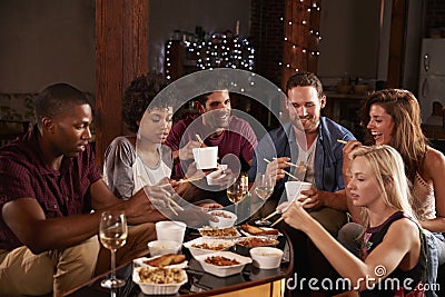 Young adults eating Chinese take-away at a party at home Stock Photo