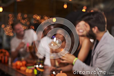 Young adults socialising at a party in a bar, defocussed Stock Photo