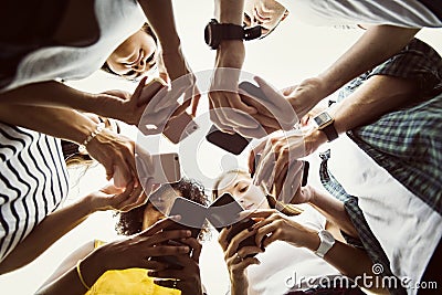 Young adults using smartphones in a circle social media and conn Stock Photo