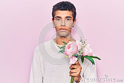 Young african amercian man holding flowers thinking attitude and sober expression looking self confident Stock Photo