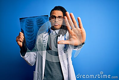 Young african american afro doctor man with dreadlocks holding chest lung xray with open hand doing stop sign with serious and Stock Photo