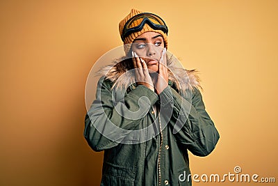 Young african american afro skier girl wearing snow sportswear and ski goggles Tired hands covering face, depression and sadness, Stock Photo