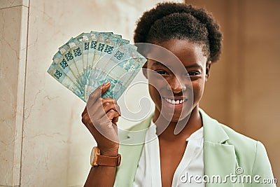 Young african american businesswoman smiling happy holding brazilian real banknotes at the city Stock Photo