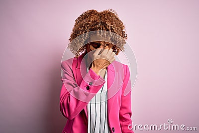 Young african american businesswoman wearing glasses standing over pink background tired rubbing nose and eyes feeling fatigue and Stock Photo