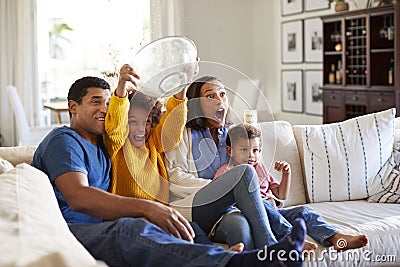 Young African American family sitting together on the sofa in their living room watching a scary movie Stock Photo