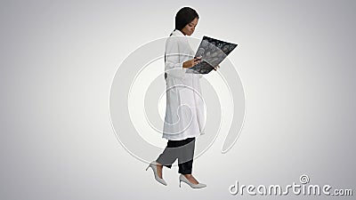 Young african american female doctor looking at xray while walki Stock Photo