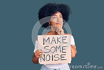 Young african american girl holding make some noise banner serious face thinking about question with hand on chin, thoughtful Stock Photo