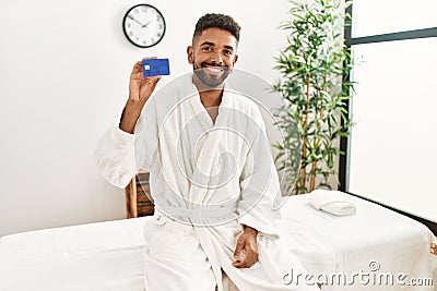 Young african american holding credit card at beauty center Stock Photo
