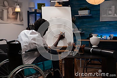 Male wheelchair user spending time doing pencil drawing Stock Photo