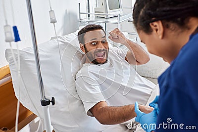 young african american nurse inserting catheter Stock Photo