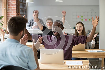 Young african american office worker celebrating achievement at Stock Photo