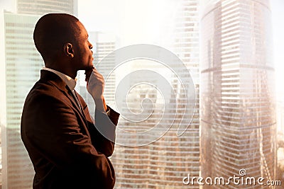 Young african-american thoughtful businessman looking through wi Stock Photo