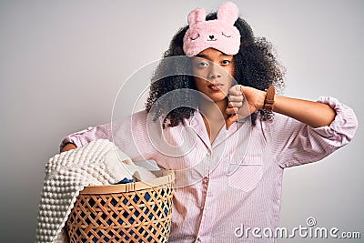 Young african american woman with afro hair wearing pajama doing laundry domestic chores with angry face, negative sign showing Stock Photo