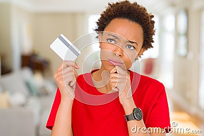 Young african american woman holding credit card serious face thinking about question, very confused idea Stock Photo