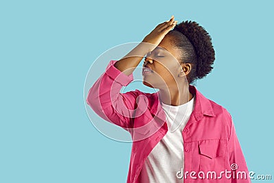 Young african american woman is showing facepalm gesture on blue background. Stock Photo