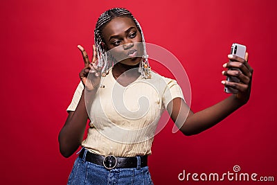 Young African American woman taking a selfie isolated on red background Stock Photo