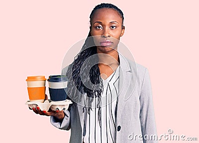 Young african american woman wearing business clothes holding take away cup of coffee thinking attitude and sober expression Stock Photo