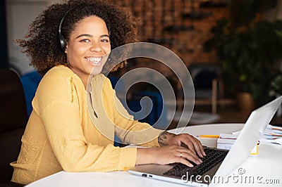 Young African-American woman wearing headset using laptop for remote work Stock Photo
