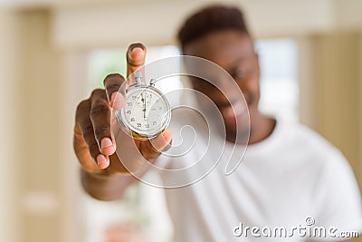 Young african man holding silver retro stopwatch counting time Stock Photo