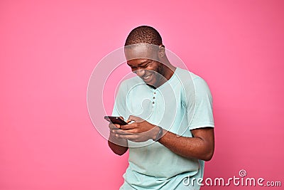 young african man looking very excited while using his cellphone Stock Photo