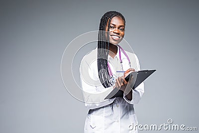 Young african medical intern doctor writing prescription on clipboard on gray background Stock Photo