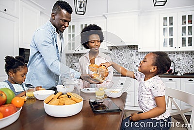 African parents with daughter enjoying breakfast at home Stock Photo