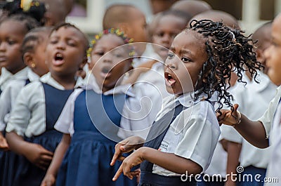 Young African school girl with beautifully decorated hair singing and dancing at pre-school in Matadi, Congo, Africa Editorial Stock Photo