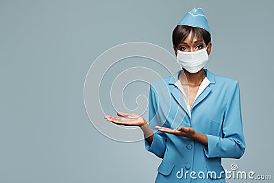 Young african stewardess wearing an antiviral mask on her face. Stock Photo